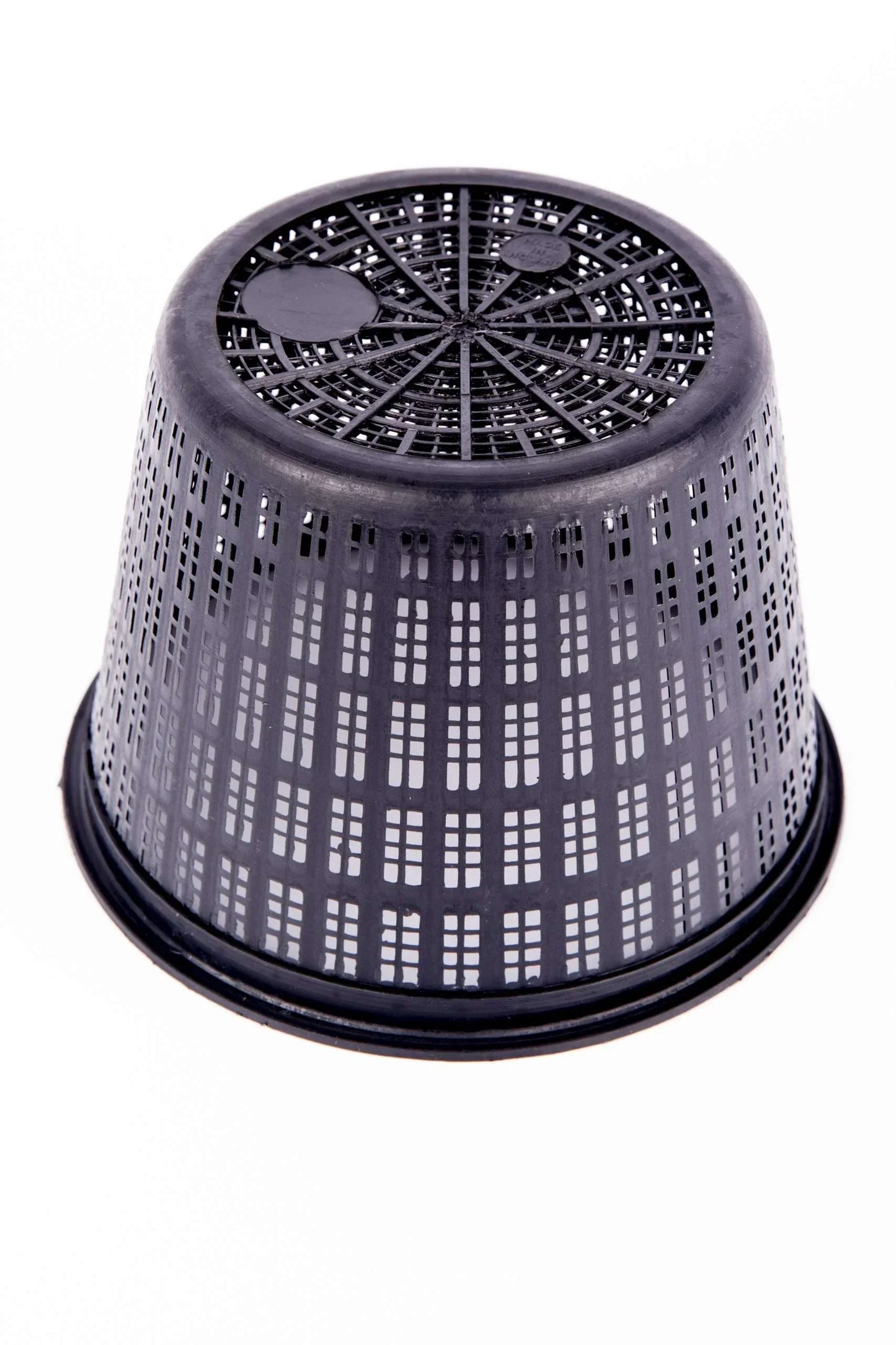 Black plastic ventilated plant pot inverted on white background