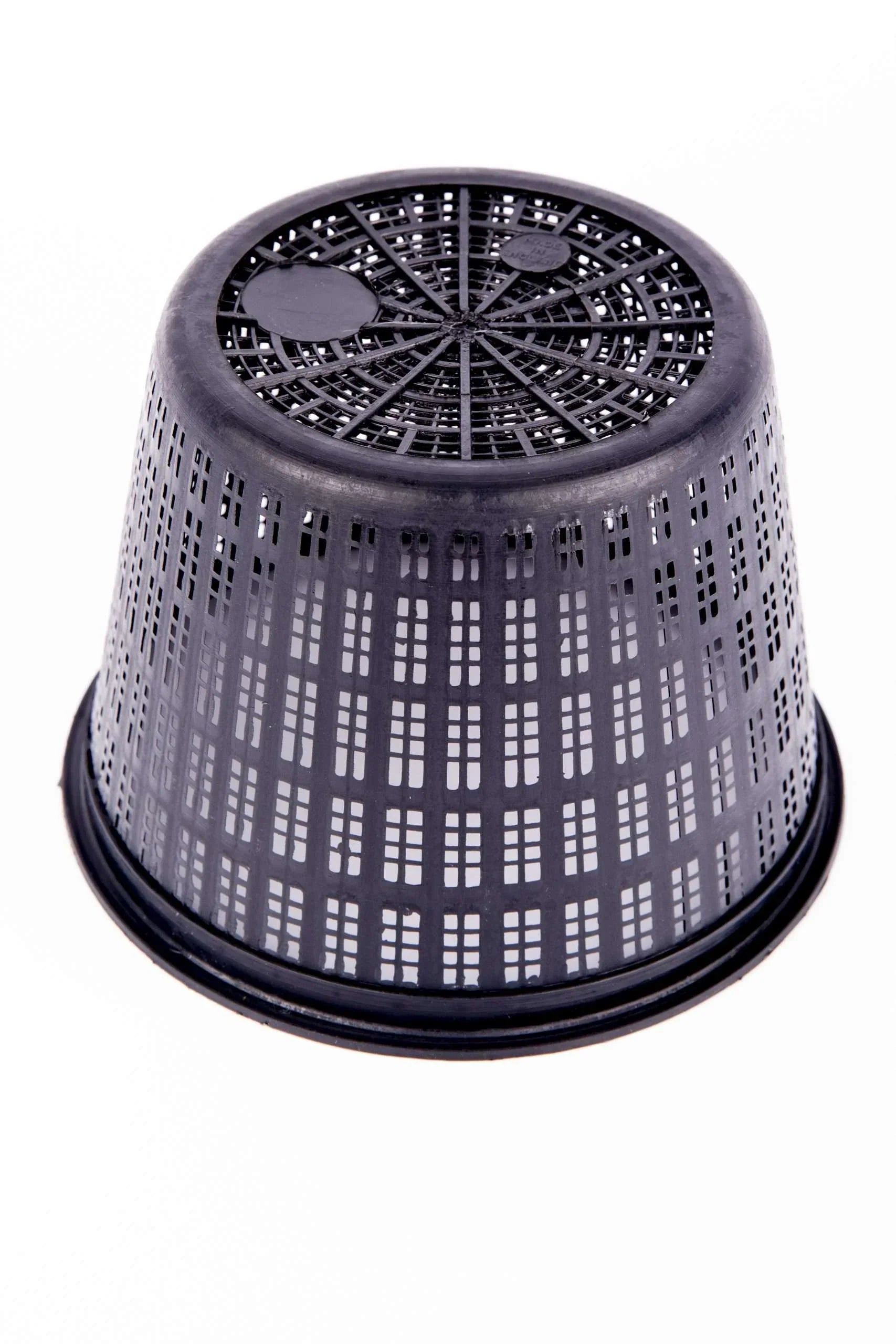 Black plastic ventilated plant pot inverted on white background