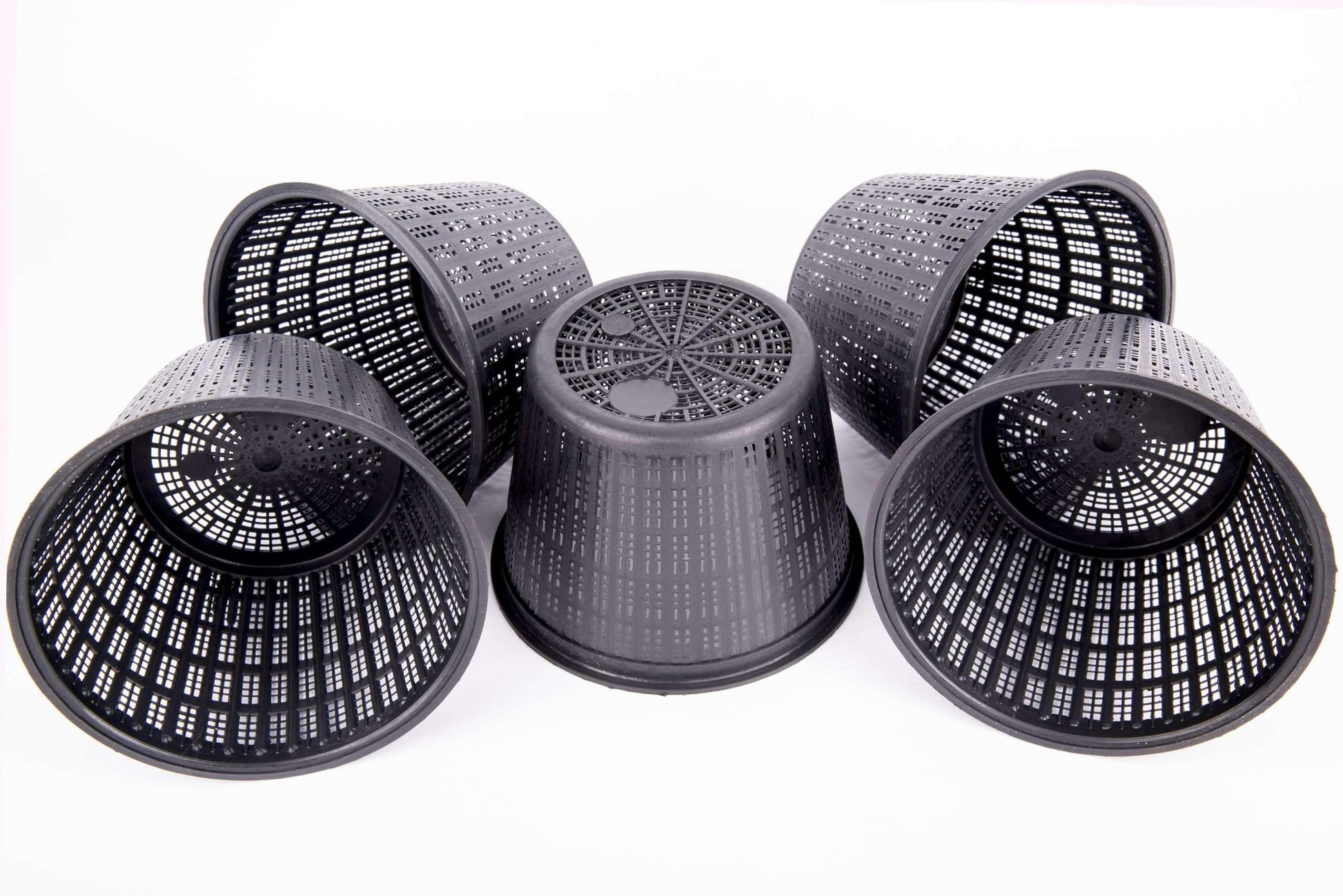 Set of five black plastic mesh plant pots with drainage holes on white background