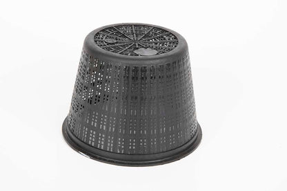Black perforated plastic plant pot turned upside down on white background